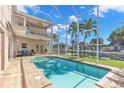 Screened-in pool with patio furniture and canal view at 41 Cypress Dr, Palm Harbor, FL 34684