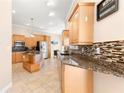 Kitchen with granite countertops and light wood cabinets at 41 Cypress Dr, Palm Harbor, FL 34684