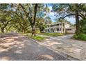 Two-story house on a tree-lined street with a brick driveway at 321 S Brooksville Ave, Brooksville, FL 34601
