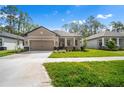 Charming single-story home featuring a well-maintained lawn and a covered entryway with stone columns at 11512 Weaver Hollow Rd, New Port Richey, FL 34654