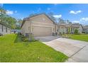 Beautiful single-story home with a two-car garage, manicured lawn, and stone accent columns at 11512 Weaver Hollow Rd, New Port Richey, FL 34654