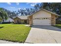 Front view of the house with a two-car garage and lush green lawn at 9142 Brooker Dr, New Port Richey, FL 34655