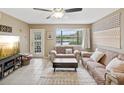 Bright living room with lake view, comfy sofas, and tiled floors at 12025 Proctor Loop # 3, New Port Richey, FL 34654