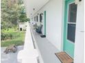 Community hallway with teal doors and seating area, overlooking a grassy lawn at 11200 86Th Ave # 204, Seminole, FL 33772