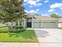 Two-story house with green exterior and three-car garage at 4264 Braemere Dr, Spring Hill, FL 34609