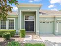 Two-story house with a green facade, double front doors, and a two-car garage at 4264 Braemere Dr, Spring Hill, FL 34609