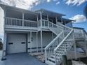 Two-story home with white exterior, balcony, and attached garage at 6428 Driftwood Dr, Hudson, FL 34667