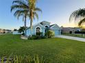 House with palm trees and a lush green lawn at 2718 Tidal Creek Dr, Holiday, FL 34691