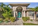 Welcoming front entrance with teal door and stone pathway at 660 N Lake Blvd, Tarpon Springs, FL 34689