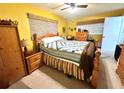 Cozy bedroom with yellow walls, vintage furnishings, and a comfortable-looking bed at 8111 Roxboro Dr, Hudson, FL 34667