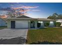 Single story home with a two-car garage and a well-maintained lawn at 9130 Horizon Dr, Spring Hill, FL 34608