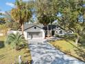 Aerial view of a single-story home with a driveway and lush landscaping at 5333 Denver Ave, Spring Hill, FL 34608