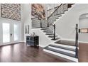 The foyer features hard wood floors, decorative chest, and a staircase with black metal railings at 6120 Marsh Trail Dr, Odessa, FL 33556