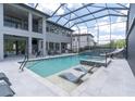 The screened-in pool features in-pool lounge chairs, a slide and a built in hot tub at 6120 Marsh Trail Dr, Odessa, FL 33556