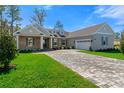 Attractive one-story home boasts a brick front, shutters, and a gray and brown brick driveway at 19364 Sheltered Hill Dr, Brooksville, FL 34601