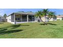 Home's backyard with screened patio, shed, and lush lawn at 1638 Swamp Rose Ln, Trinity, FL 34655