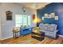 Living room with gray couch, coffee table, and wood-look flooring at 1775 Cupecoy Cir # O4, Lutz, FL 33558
