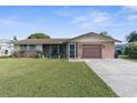 Brick ranch home with attached garage and landscaped yard at 10316 Amadeus Dr, Port Richey, FL 34668