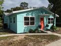 Side view of charming teal home with coral door at 1943 Park Ave, Tarpon Springs, FL 34689