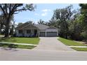 Beautiful single-story house with a nice front porch, green lawn, and attached garage with wide driveway at 6392 Summit View Dr, Brooksville, FL 34601