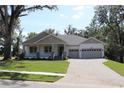 Attractive single-story home showcasing a cozy front porch, well-kept lawn, and an attached two-car garage at 6392 Summit View Dr, Brooksville, FL 34601