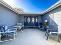 Inviting front entry with a covered patio and seating area at 7310 Rockwood Dr, Port Richey, FL 34668