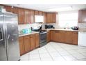 Kitchen with wood cabinets, stainless steel appliances, and tile floor at 7204 Westcott Dr, Port Richey, FL 34668