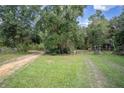 Gravel driveway leading through a wooded area at 13080 Old Crystal River Rd, Brooksville, FL 34601