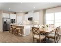 Bright kitchen and dining area with white cabinetry, stainless steel appliances, and an island with bar seating at 16855 Castoro Dr, Port Charlotte, FL 33953