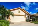Single-story house with a two-car garage and lush landscaping at 20743 Nectarine Pl, Land O Lakes, FL 34637