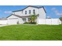 Two-story house with a white fence, driveway, and lush green lawn at 5519 Alderwood St, Spring Hill, FL 34606