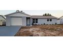 Newly renovated light gray house with white garage door at 6417 Sutherland Ave, New Port Richey, FL 34653