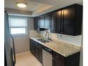Updated kitchen with dark cabinets and granite counters at 6417 Sutherland Ave, New Port Richey, FL 34653