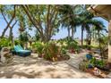 Secluded backyard oasis featuring a brick patio, mature trees, and lounge seating for relaxation at 8231 Coral Creek Loop, Hudson, FL 34667
