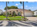 Charming single-story home with lush landscaping and a paver driveway leading to a two-car garage at 8231 Coral Creek Loop, Hudson, FL 34667