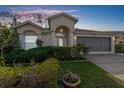 Single-story house with a gray screen door garage and lush landscaping at 10906 New Brighton Ct, New Port Richey, FL 34654