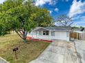 Charming single story home with a large tree and a long driveway at 11231 Snyder Ave, Port Richey, FL 34668