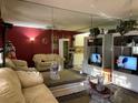 Bright living room with mirrored wall and comfy beige sofas at 20857 Haulover Cv # B-13, Lutz, FL 33558