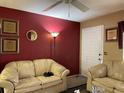 Living room with beige sofas and red walls at 20857 Haulover Cv # B-13, Lutz, FL 33558
