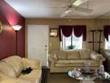 Living room features beige sofas, a window, and a door at 20857 Haulover Cv # B-13, Lutz, FL 33558