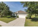 Charming home on a well-manicured lawn with a large driveway and two-car garage at 2293 Dog Leg Ct, Brooksville, FL 34604