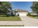Charming single-story home featuring a well-manicured lawn, two-car garage, and inviting entrance at 2293 Dog Leg Ct, Brooksville, FL 34604