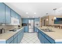 Modern kitchen featuring stainless steel appliances and blue cabinetry at 6450 Trade Ct, Spring Hill, FL 34606