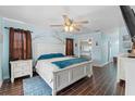 This bedroom features a large bed with a ceiling fan and wood-look floors at 6450 Trade Ct, Spring Hill, FL 34606