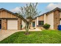 Tan two-story home with a garage and nicely landscaped lawn at 7499 Heather Walk, Weeki Wachee, FL 34613