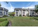 View of condo building from the back, showing landscaping and patio at 8765 Bardmoor Blvd # 208, Seminole, FL 33777