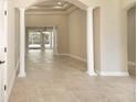 Spacious living area featuring tile floors, white columns, and an open layout at 10441 Garda Dr, Trinity, FL 34655