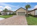 Two-story house with a gray garage door and a brick driveway at 10693 Calluna Dr, Odessa, FL 33556