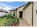 Front entry with a walkway, landscaping, and a light fixture at 10693 Calluna Dr, Odessa, FL 33556