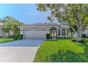 One-story home with a two-car garage and lush green lawn at 480 Fort Mill Ln, Spring Hill, FL 34609